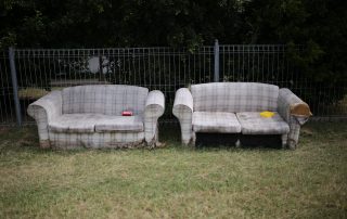 two old sofas in a field